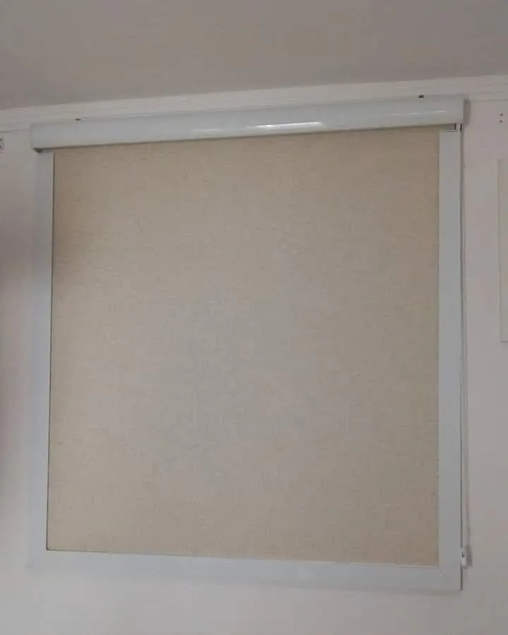 Persiana rolô de tecido bege com bandô e guias laterais brancas