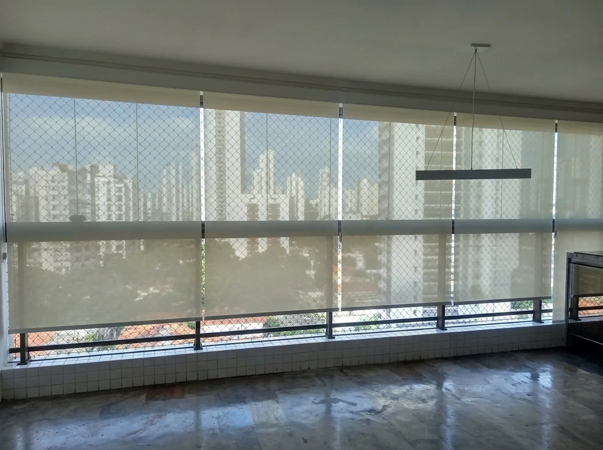 Persianas rolô tela solar parcialmente recolhidas em apartamento com vista